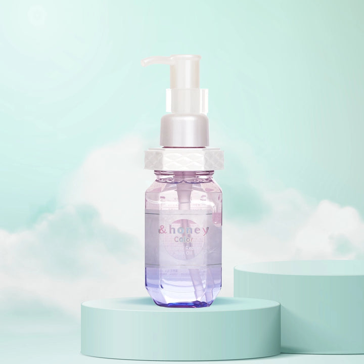 A bottle of &Honey Color Control Repair Hair Oil with a pump dispenser, displayed on a teal pedestal with a light blue background, suggesting a nourishing and care-related product.