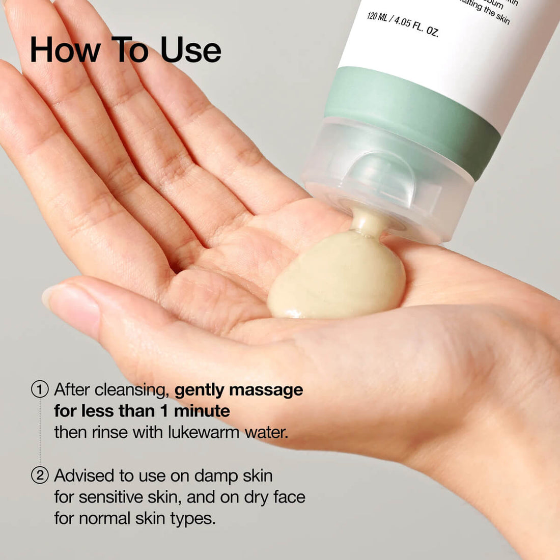 Hand holding a skincare product with usage instructions on a gray background