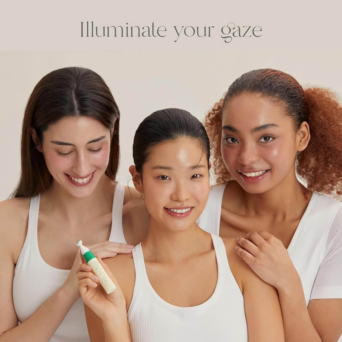 Three women holding a skincare product with text 'Illuminate your gaze' on a beige background
