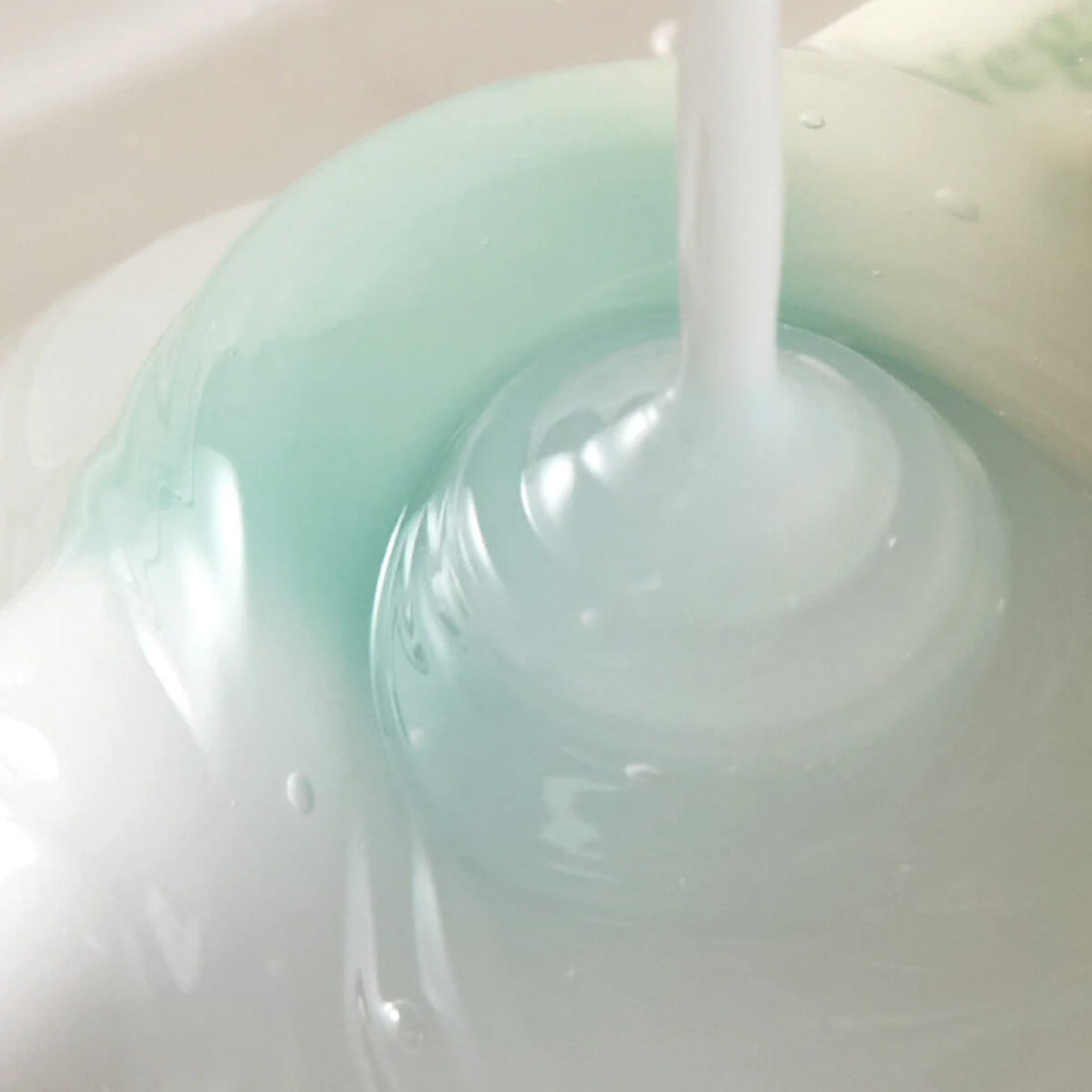 Close-up of a bottle cap with a white cap on a light green background