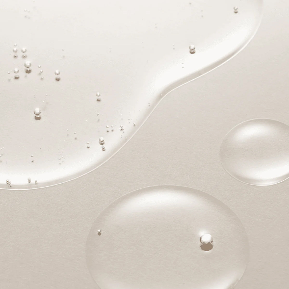 Close-up of white liquid with pearl-like beads on a light gray background
