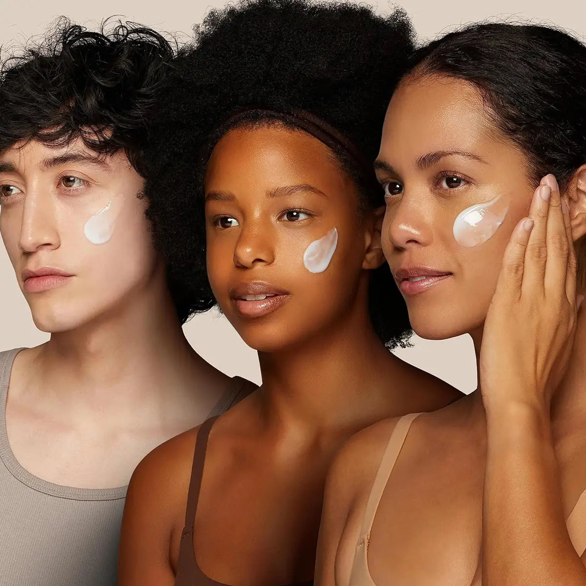 Three individuals with a product applied to their faces against a neutral background
