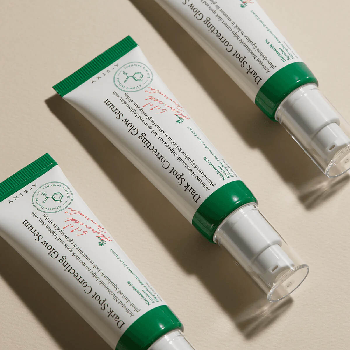 Two tubes of Darl Sport Covering Glow Serum on a beige background