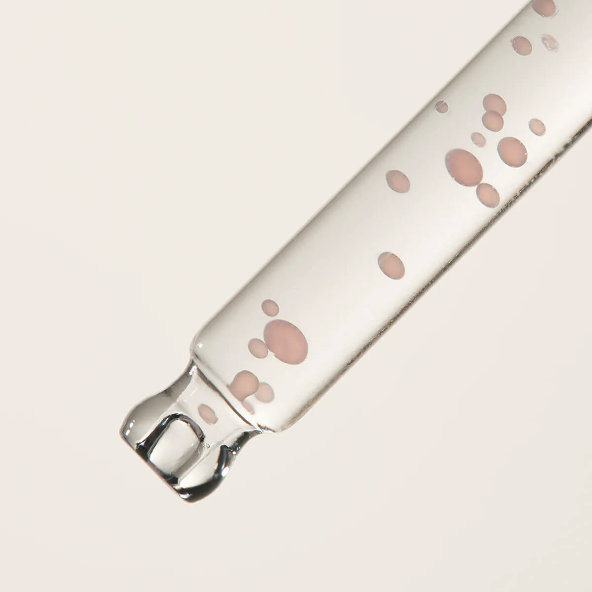 Clear glass product with pink paw prints on a light gray background