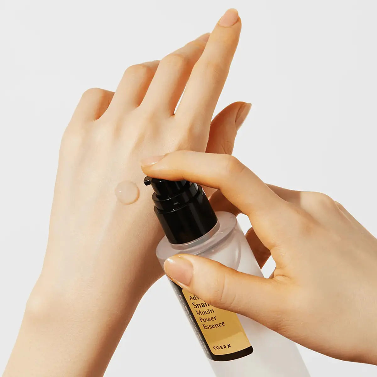 Hand applying a cosmetic product from a bottle labeled 'Cosrx'.