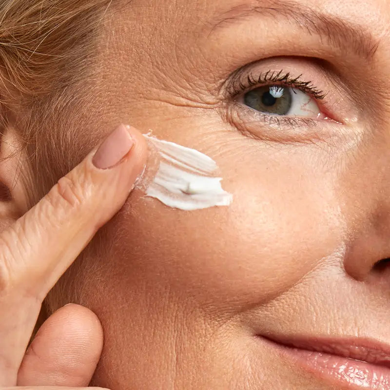 Close-up of a person applying anti-aging cream to their face