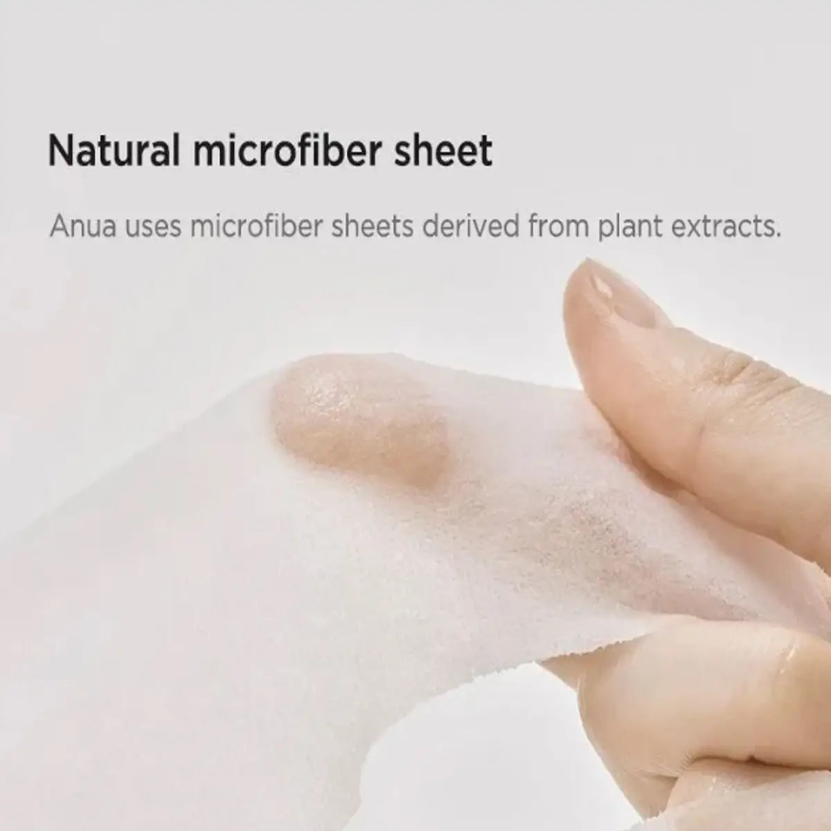 Hand holding a natural microfiber sheet with text about plant extracts