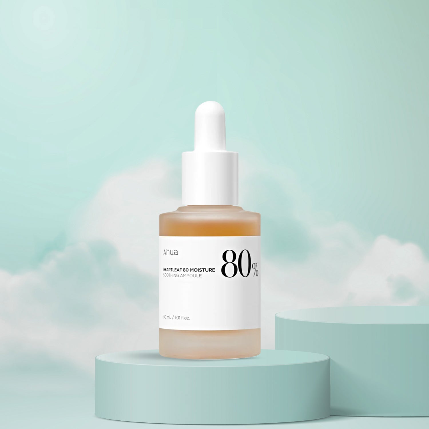 A clear glass dropper bottle of Anua Heartleaf 80% Soothing Ampoule on a pastel green pedestal with a soft focus background.