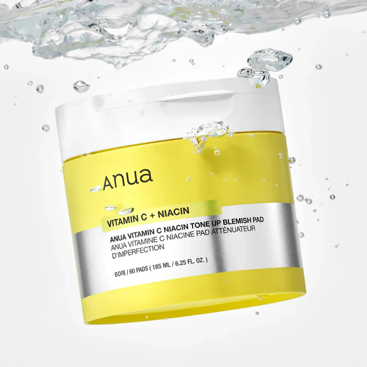 Anua Vitamin C + Niacin skincare product packaging with water droplets on a white background