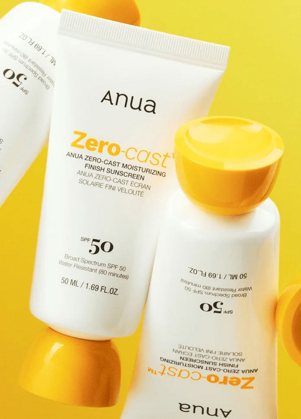 Two bottles of Anua Zero Cast Sunscreen on a yellow background