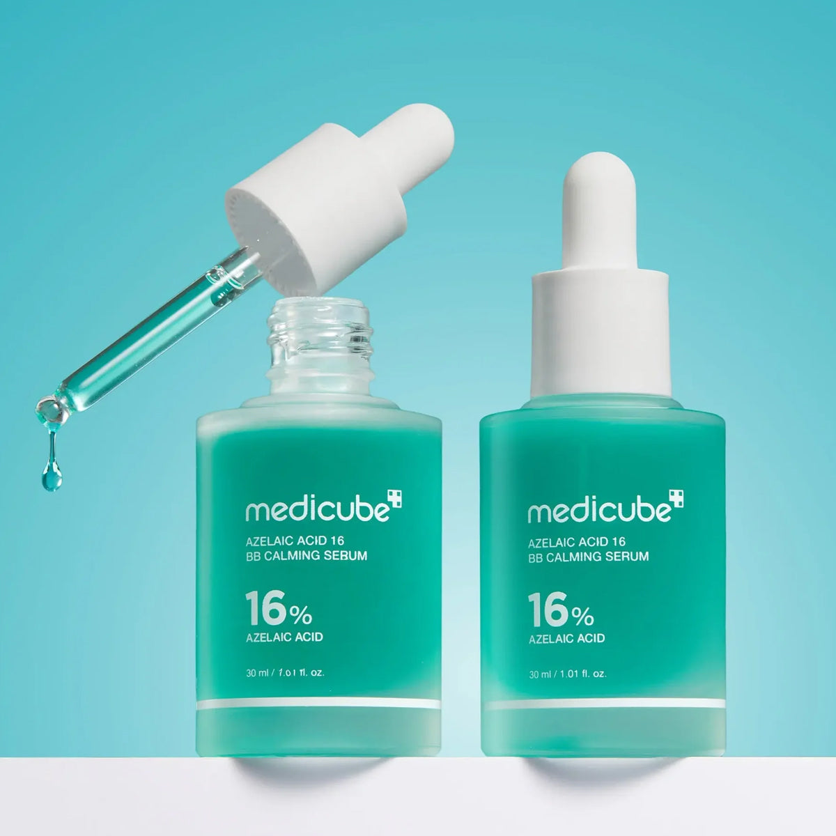 Two bottles of Medicube serum with droppers on a light blue background