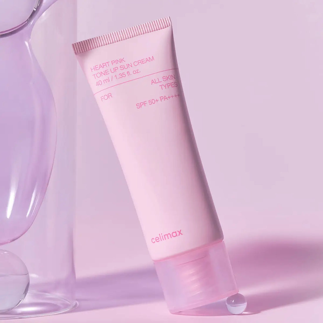 Pink sun cream tube with 'celimax' branding on a light pink background