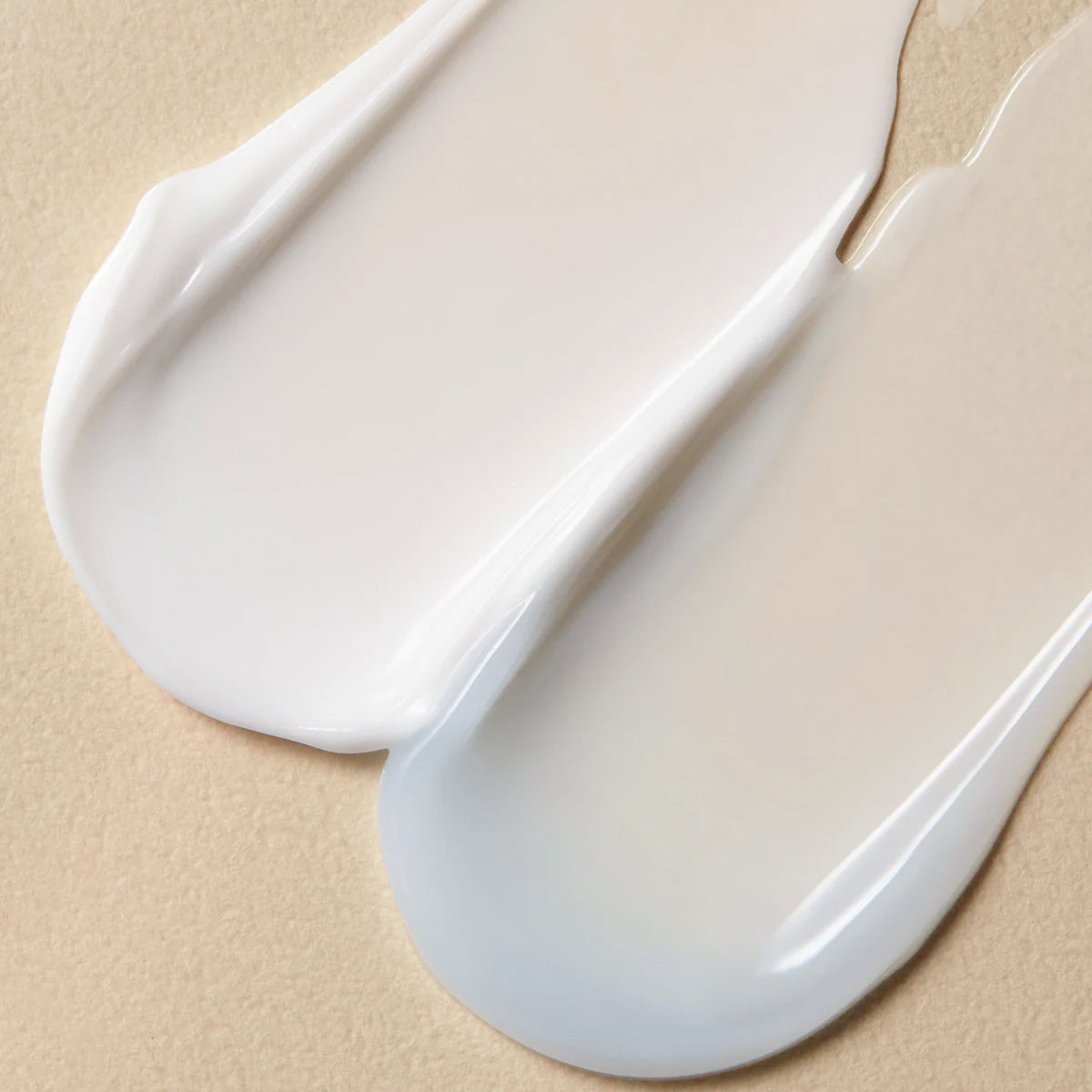 Close-up of two white ceramic spoons on a beige background
