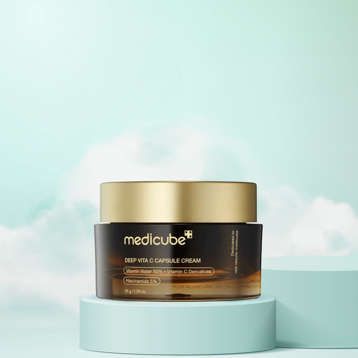 A jar of Deep Vita C Capsule Cream by Medicube, placed on a pedestal against a sky with clouds, indicating a skincare product with brightening and anti-aging benefits.
