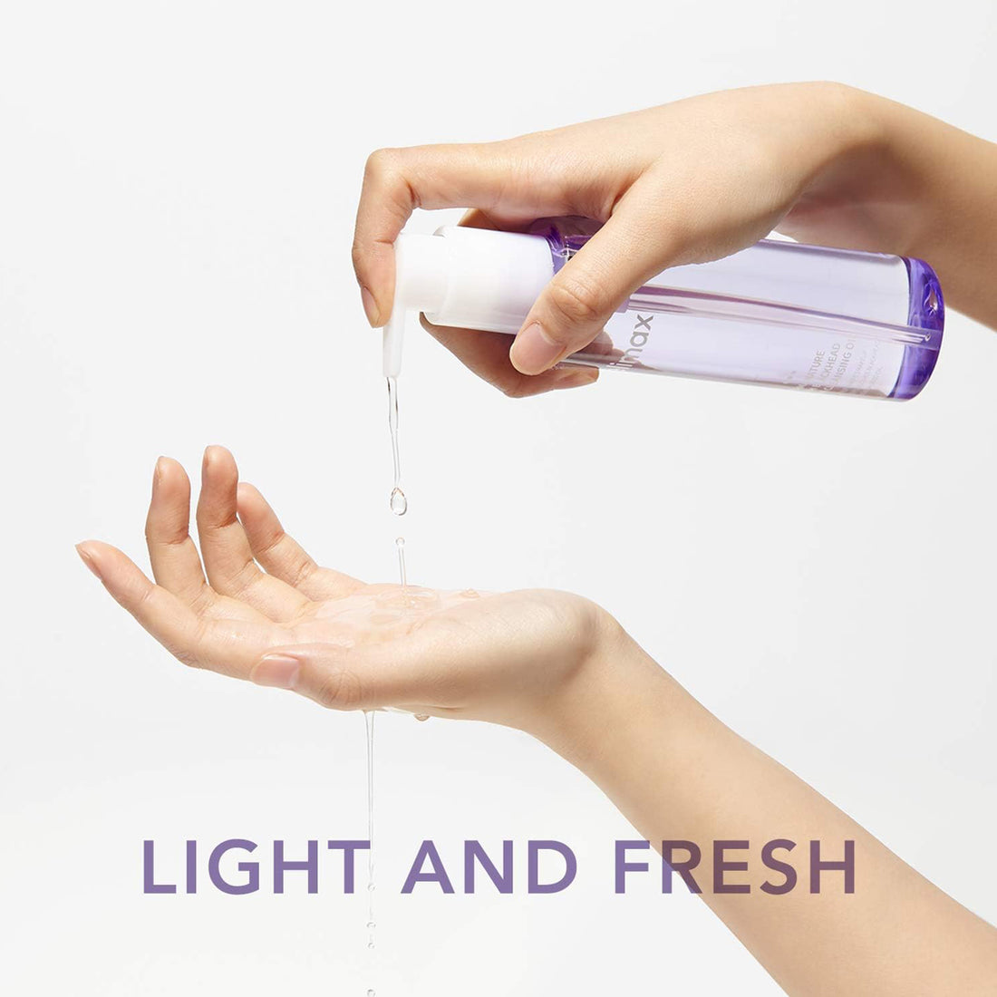 Hand holding a small bottle with liquid being poured onto another hand, against a white background.