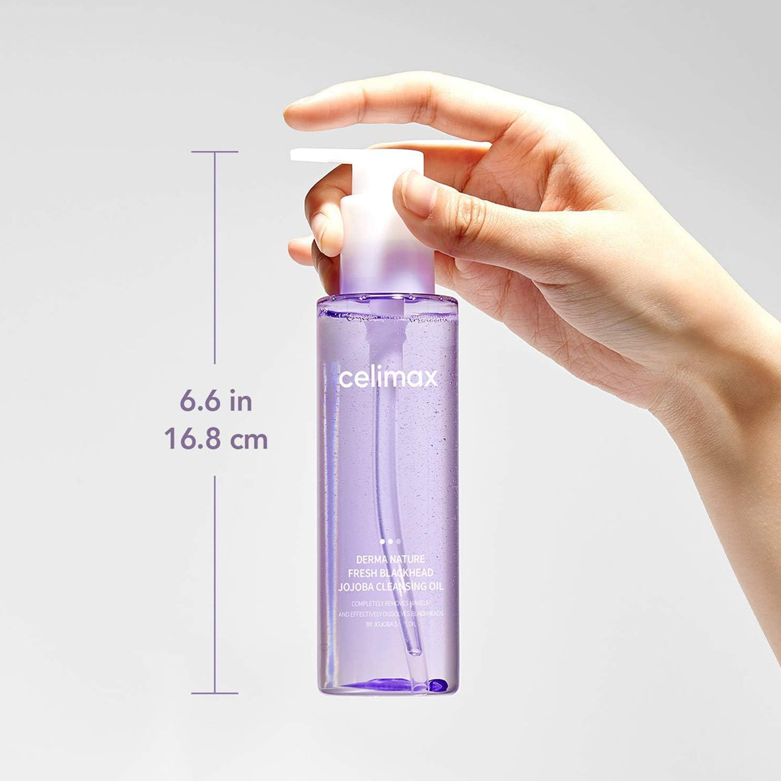 Hand holding a purple bottle labeled 'celimax' with measurements on a light gray background