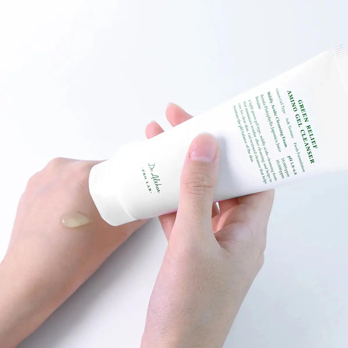 Hand holding a bottle of Delfonics Green White Amino Gel Cleanser with a small amount on the skin.