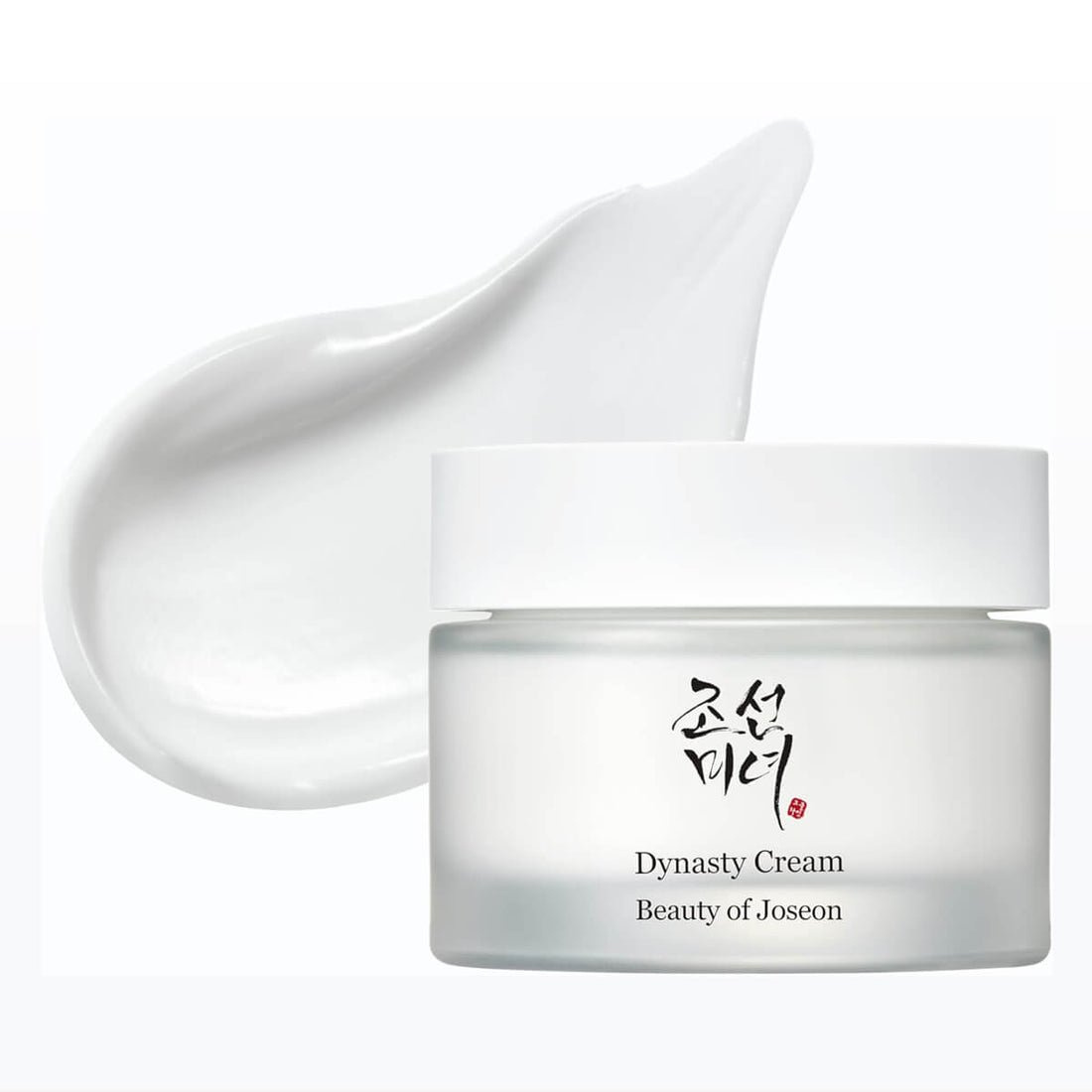 Jar of Dynasty Cream with a white applicator on a white background