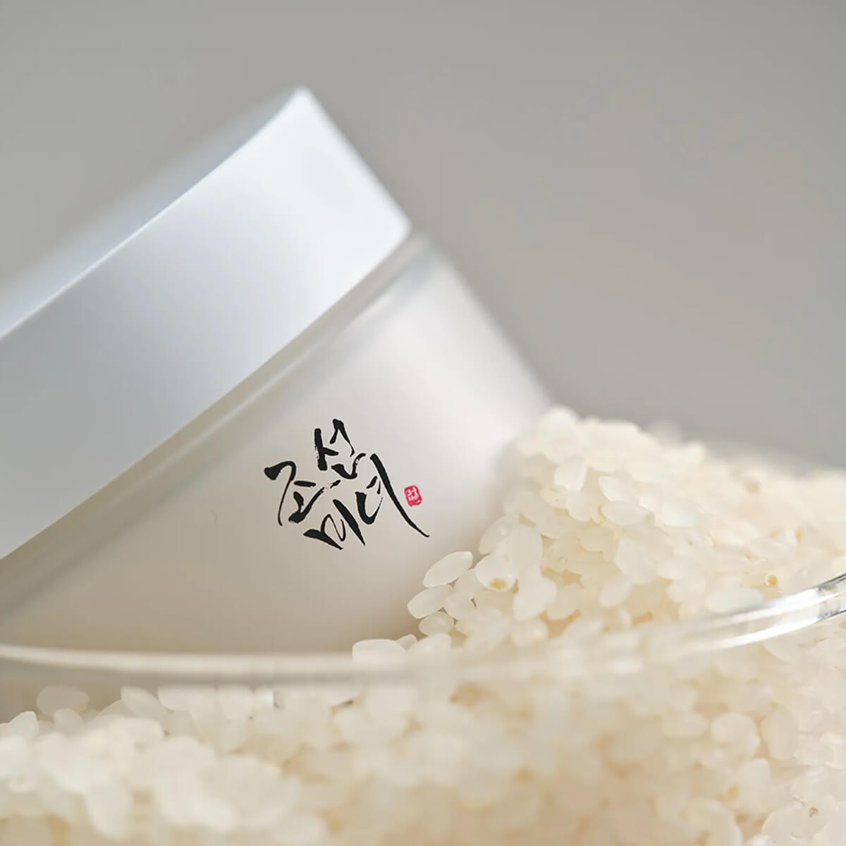 White rice in a triangular container with a brand logo on a light gray background