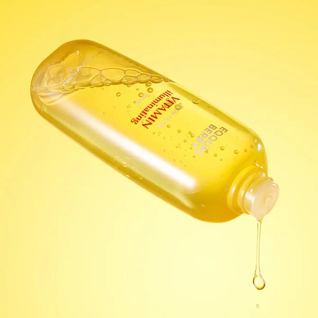 Eqqualberry Vitamin Illuminating Toner  bottle with a droplet on a yellow background