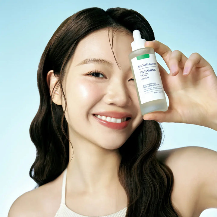 Woman holding a Eqqualberry Swimming Pool Ampoule against a light blue background
