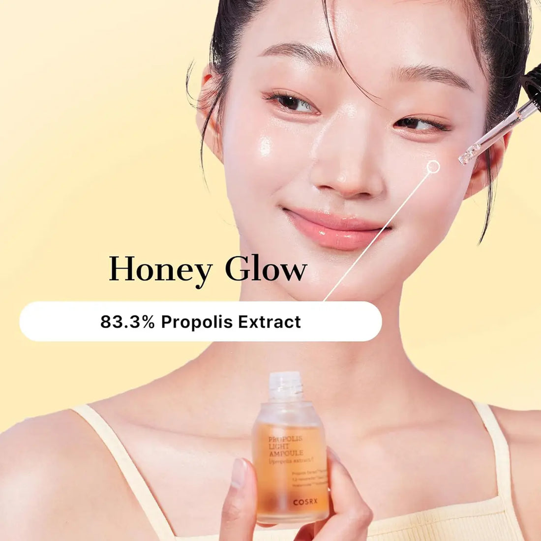 Woman holding a bottle labeled 'Honey Glow' with propolis extract on a yellow background
