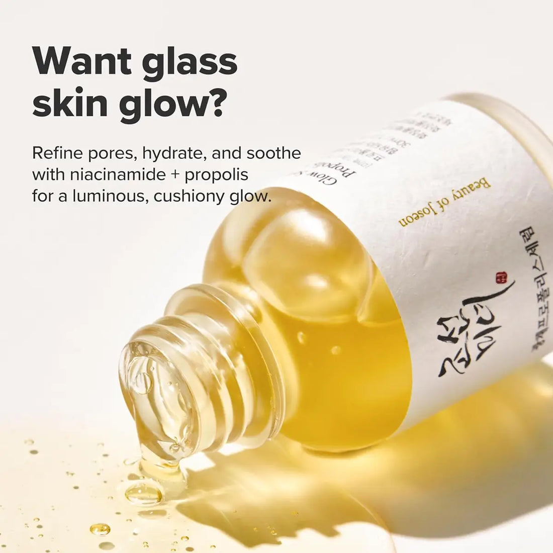 Skincare bottle with yellow liquid and text about glass skin glow on a light background