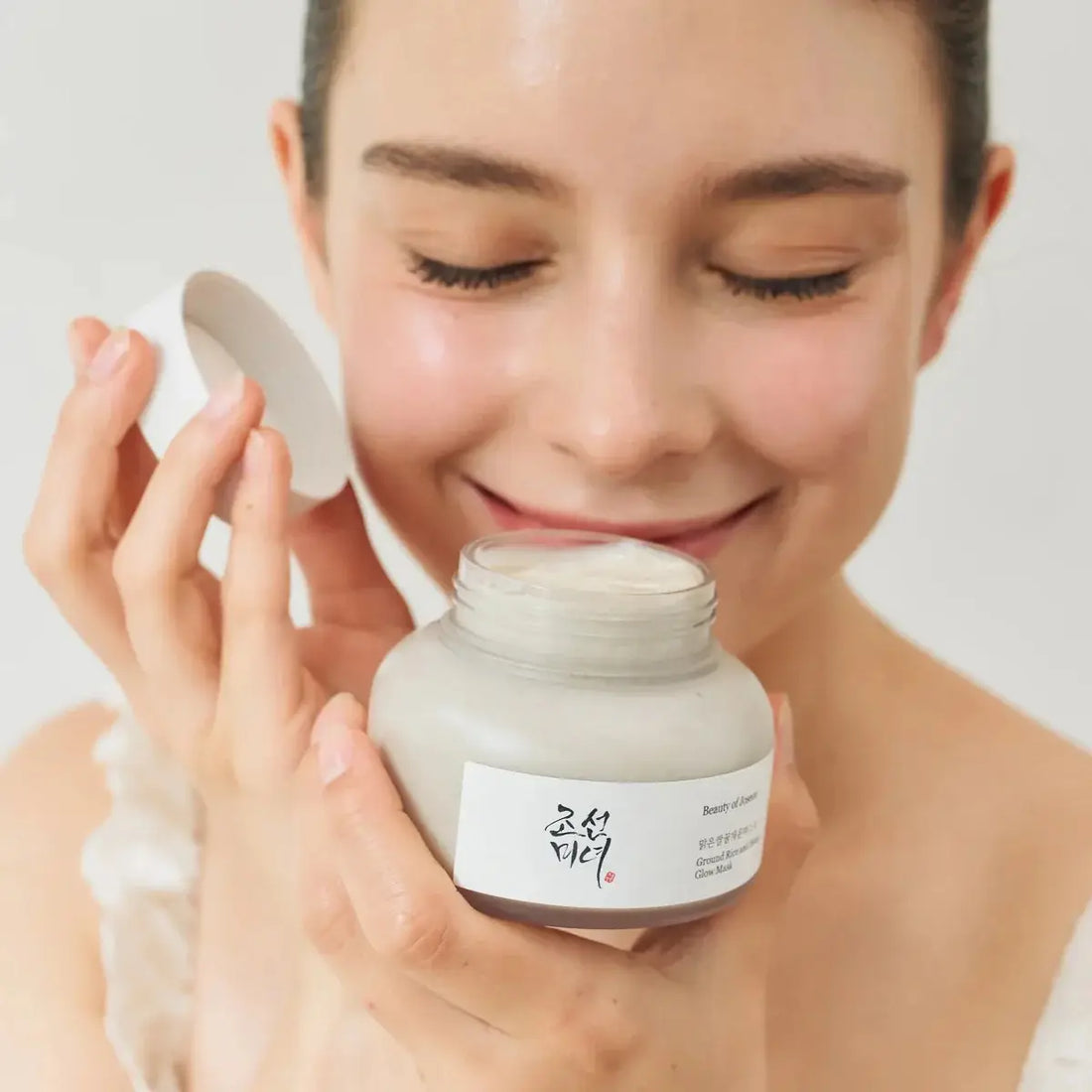 Woman holding a jar of Beauty of Joseon Rice Honey Glow Mask with a white background