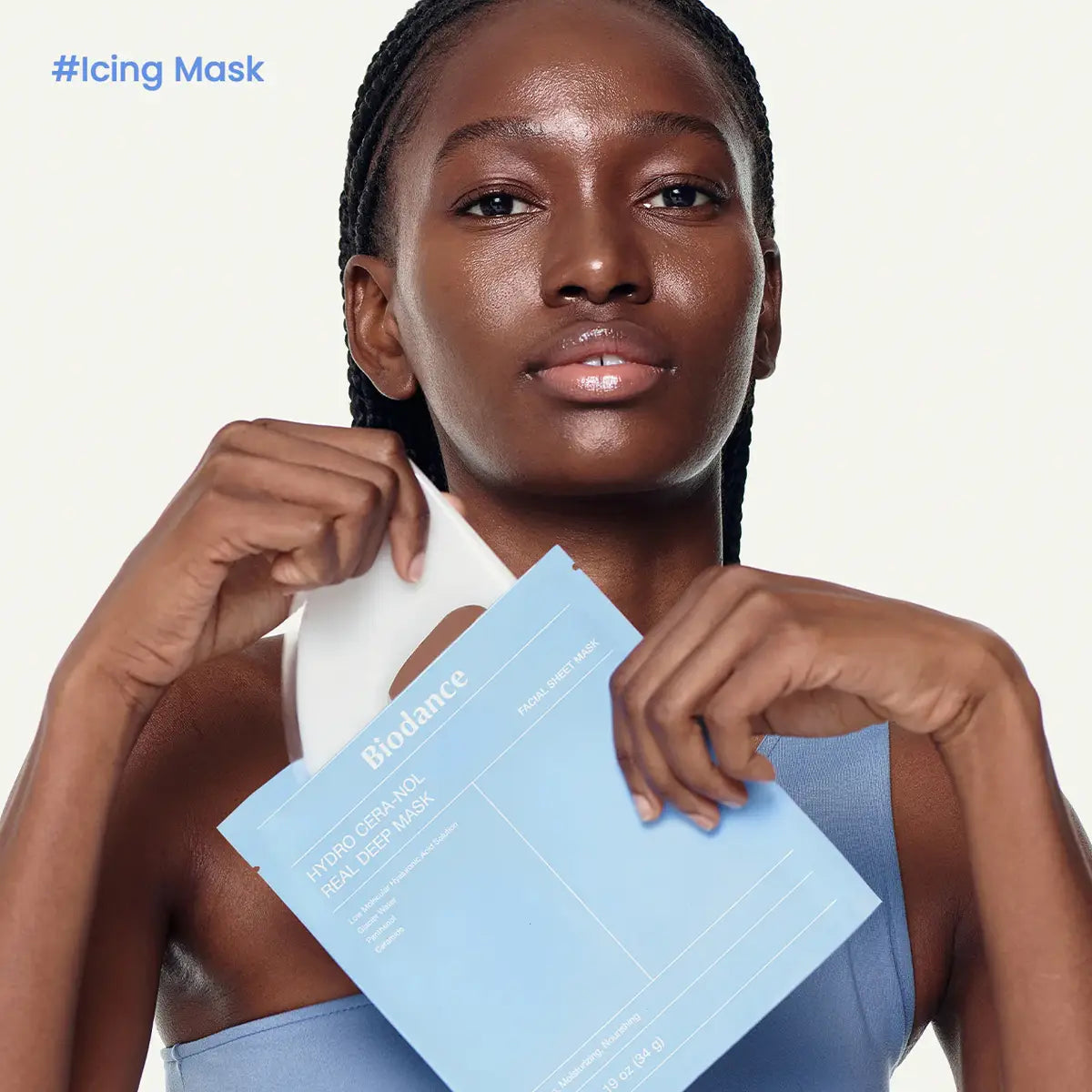 Woman holding a blue Biodance mask packet with '#Icing Mask' text on a white background