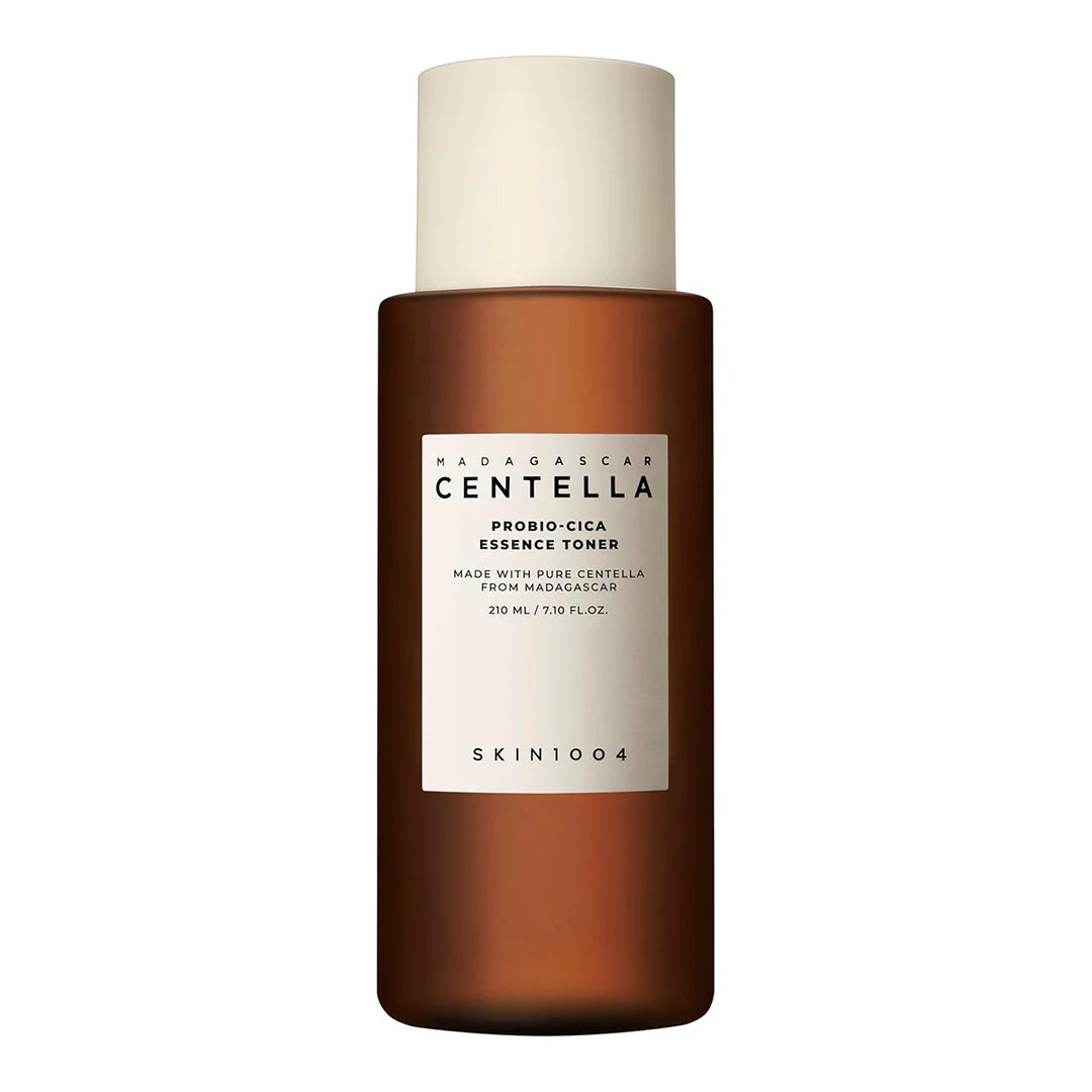 A bottle of Madagascar Centella Probio-Cica Essence Toner by Skin1004, with a brown tinted liquid visible through the transparent glass.
