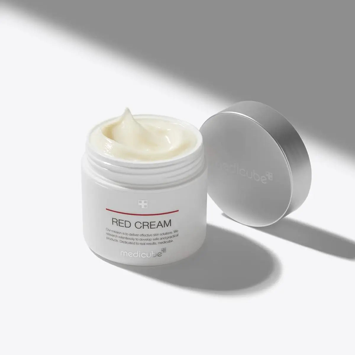 Jar of Red Cream with a white lid on a light gray background