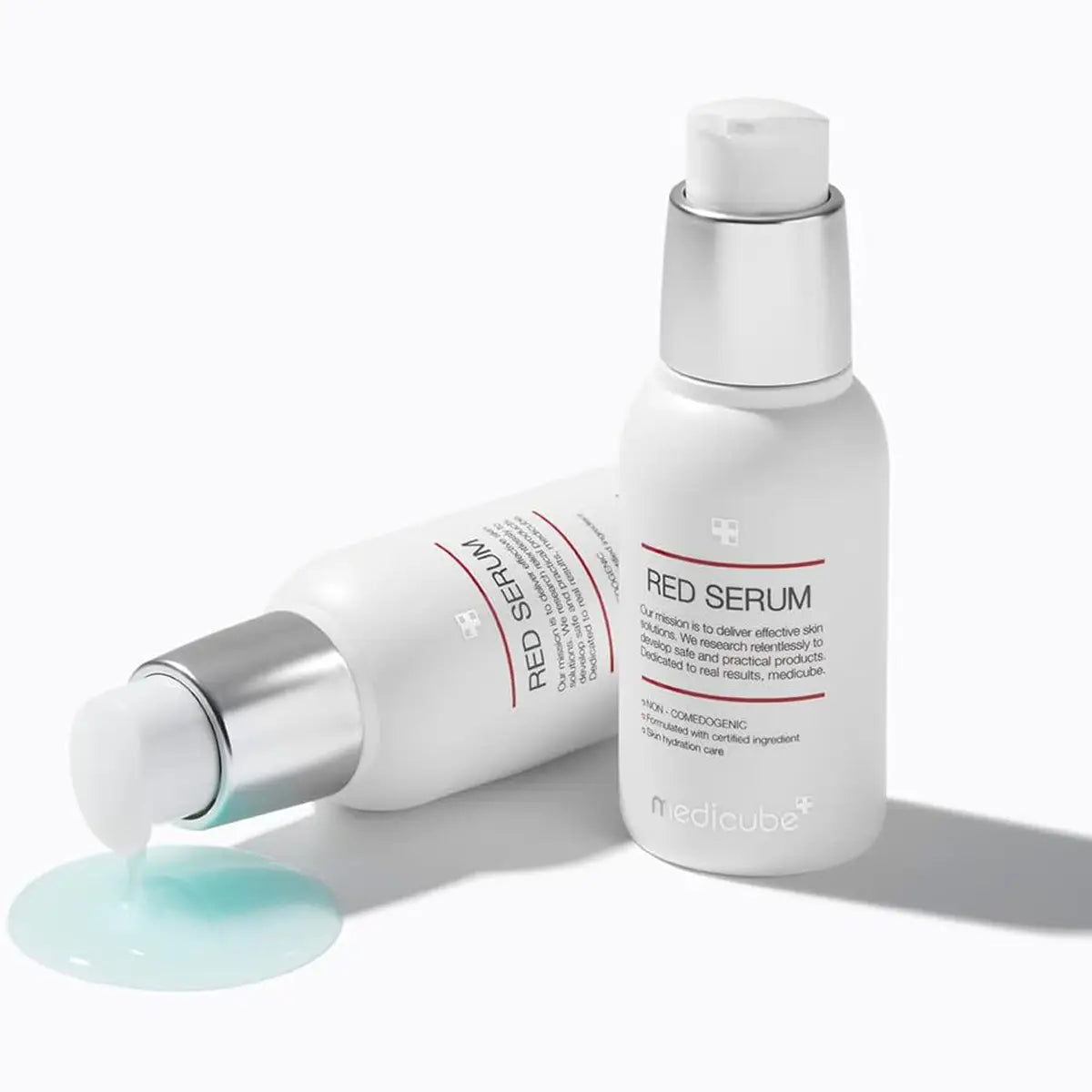 Two bottles of Red Serum with a droplet of serum on a white background