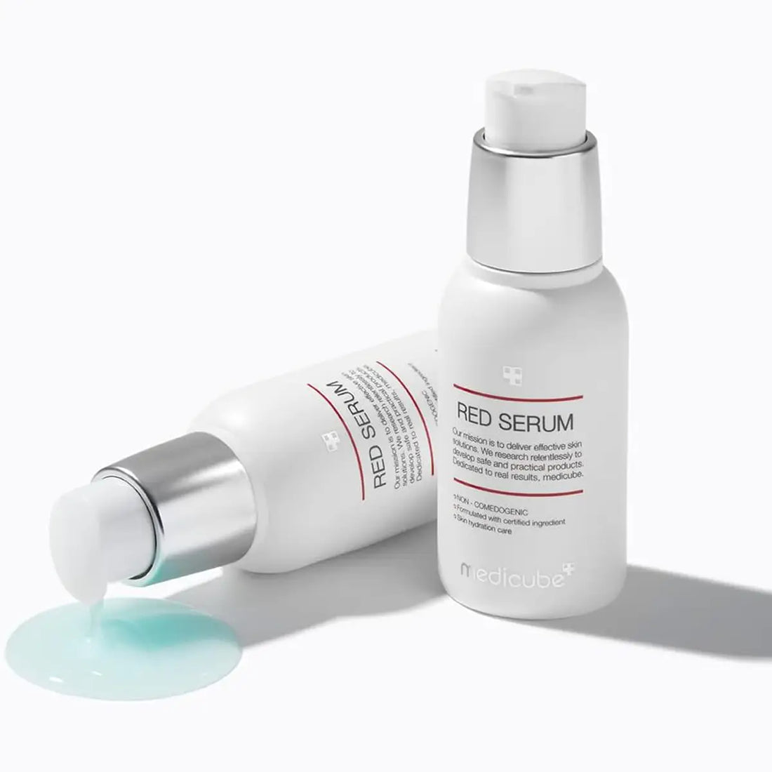 Two bottles of Red Serum with a droplet of serum on a white background