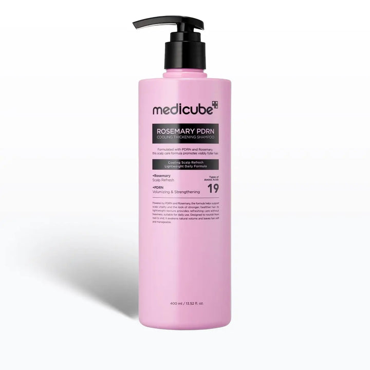 Pink shampoo bottle with black pump on a white background