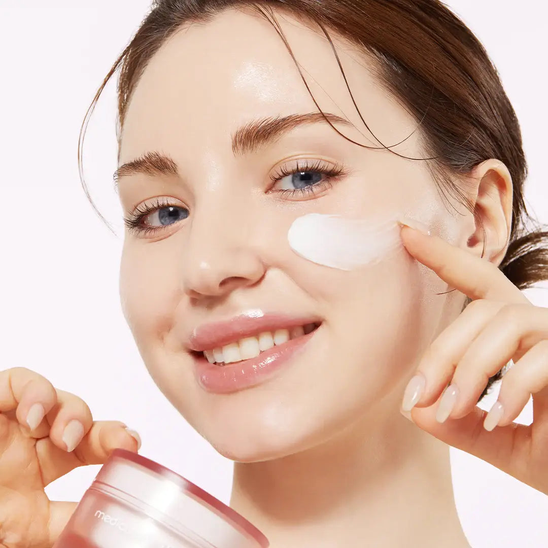 Woman applying Medicube Triple Collagen Cream on face