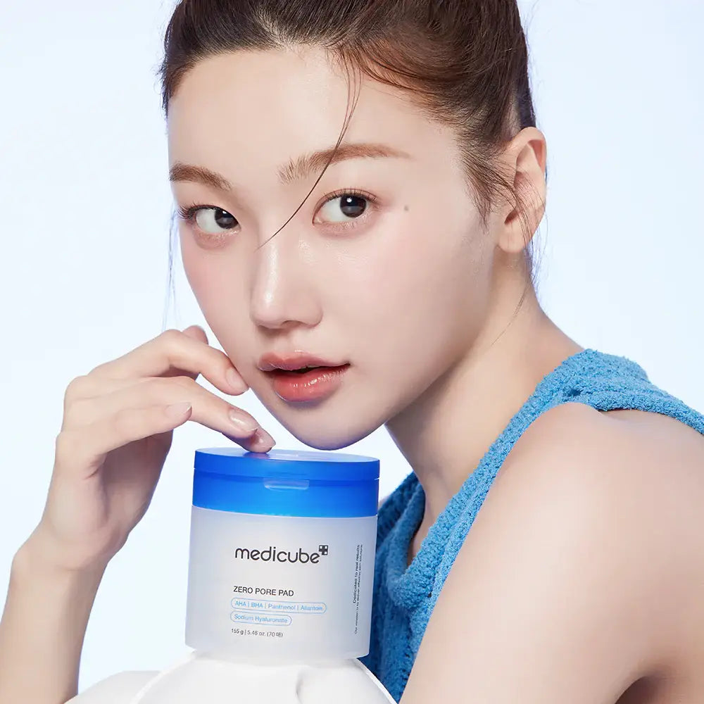 Woman holding a Medicube product with a plain background