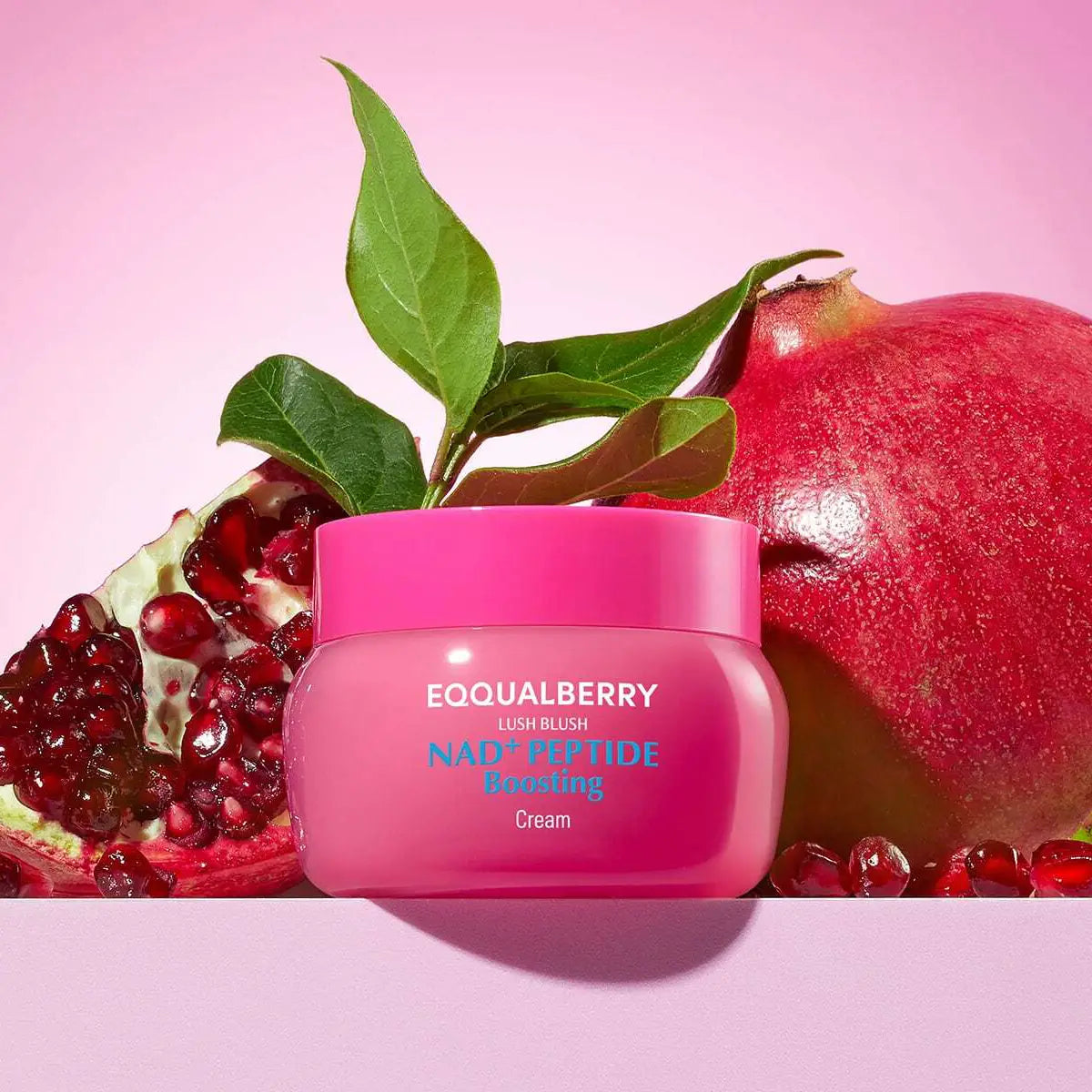 Eqqualberry NAD+ Peptide Boosting Cream with pomegranate and leaves on a pink background
