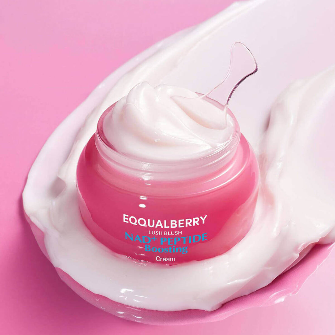 Pink jar of cream with visible brand name on a pink background