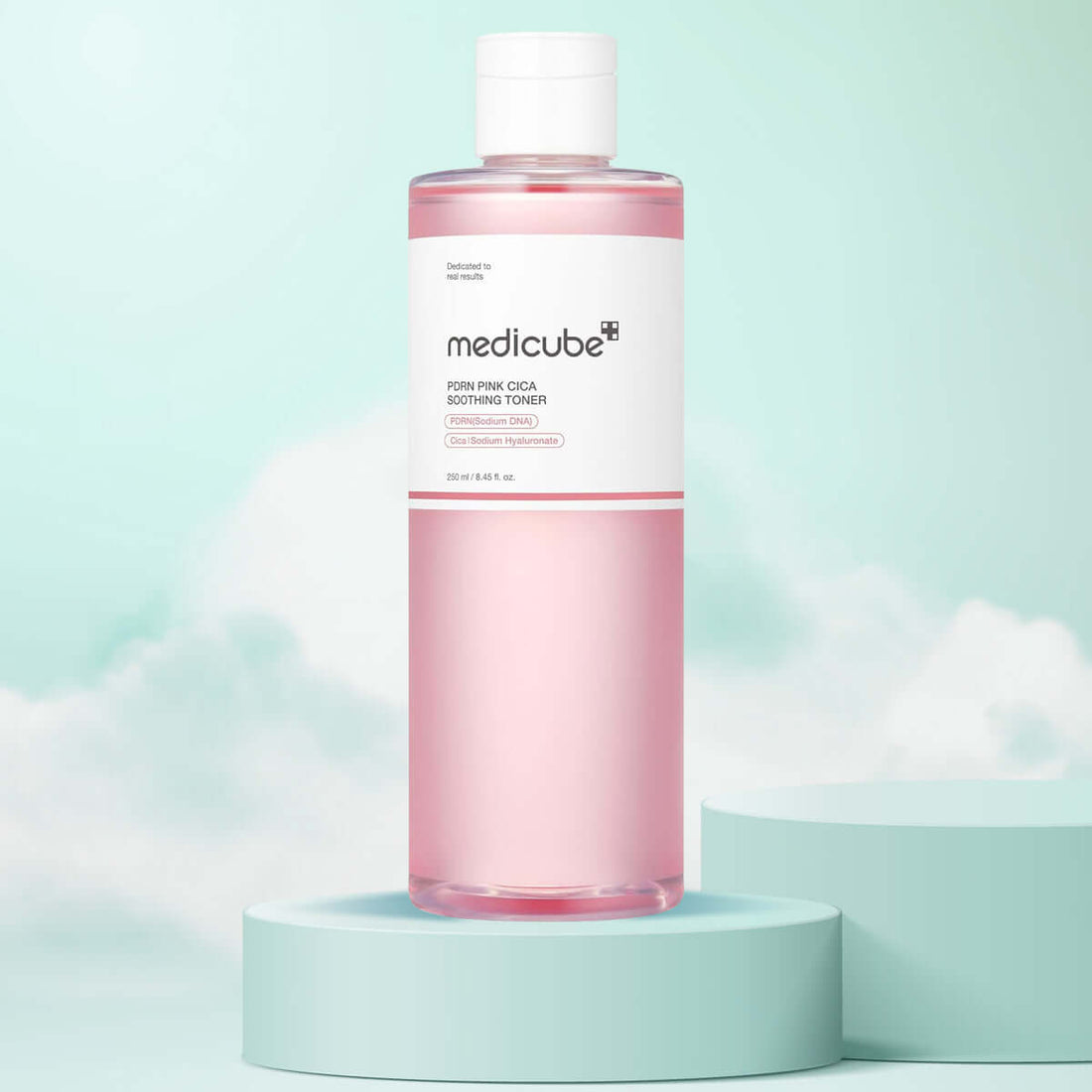 Pink bottle of Medicube toner on a light blue platform with a light blue background