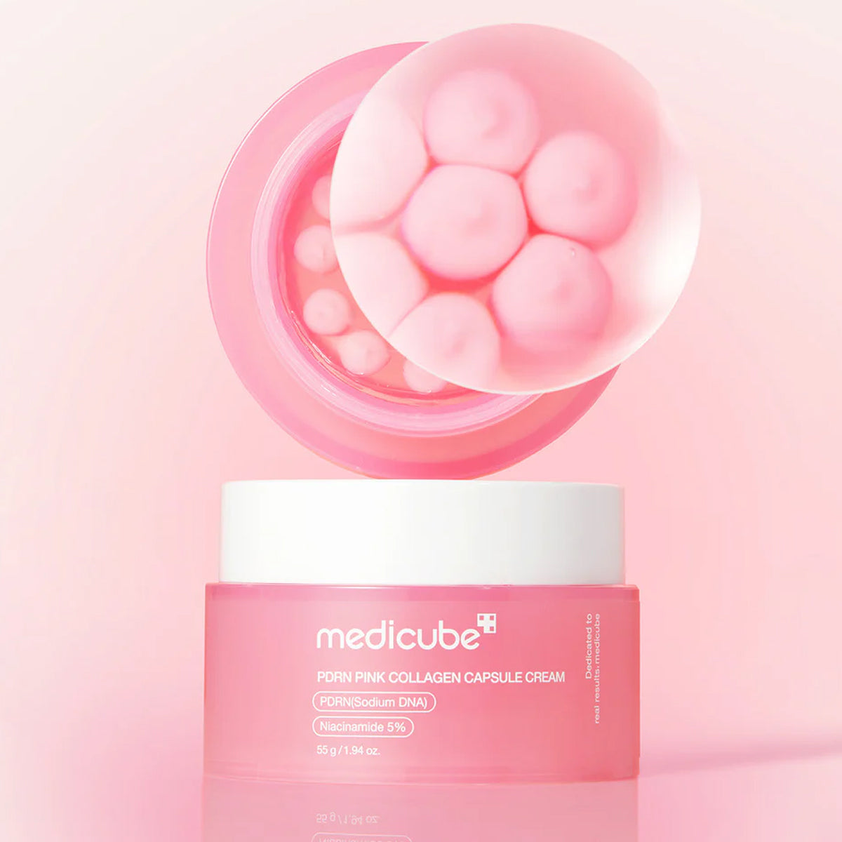 Pink collagen capsule cream with open lid on a pink background