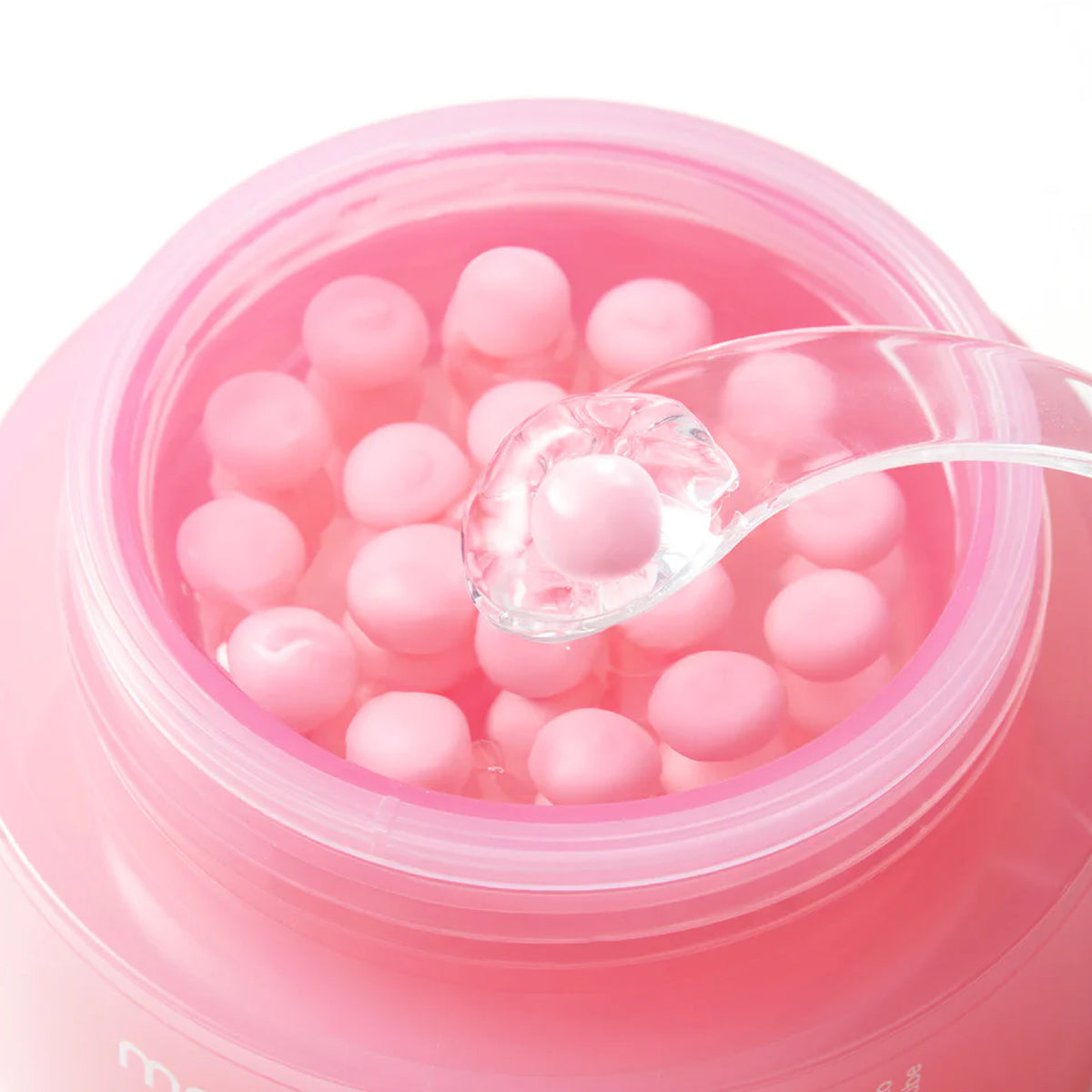 Pink gelatin dessert with tapioca pearls in a clear bowl on a white background