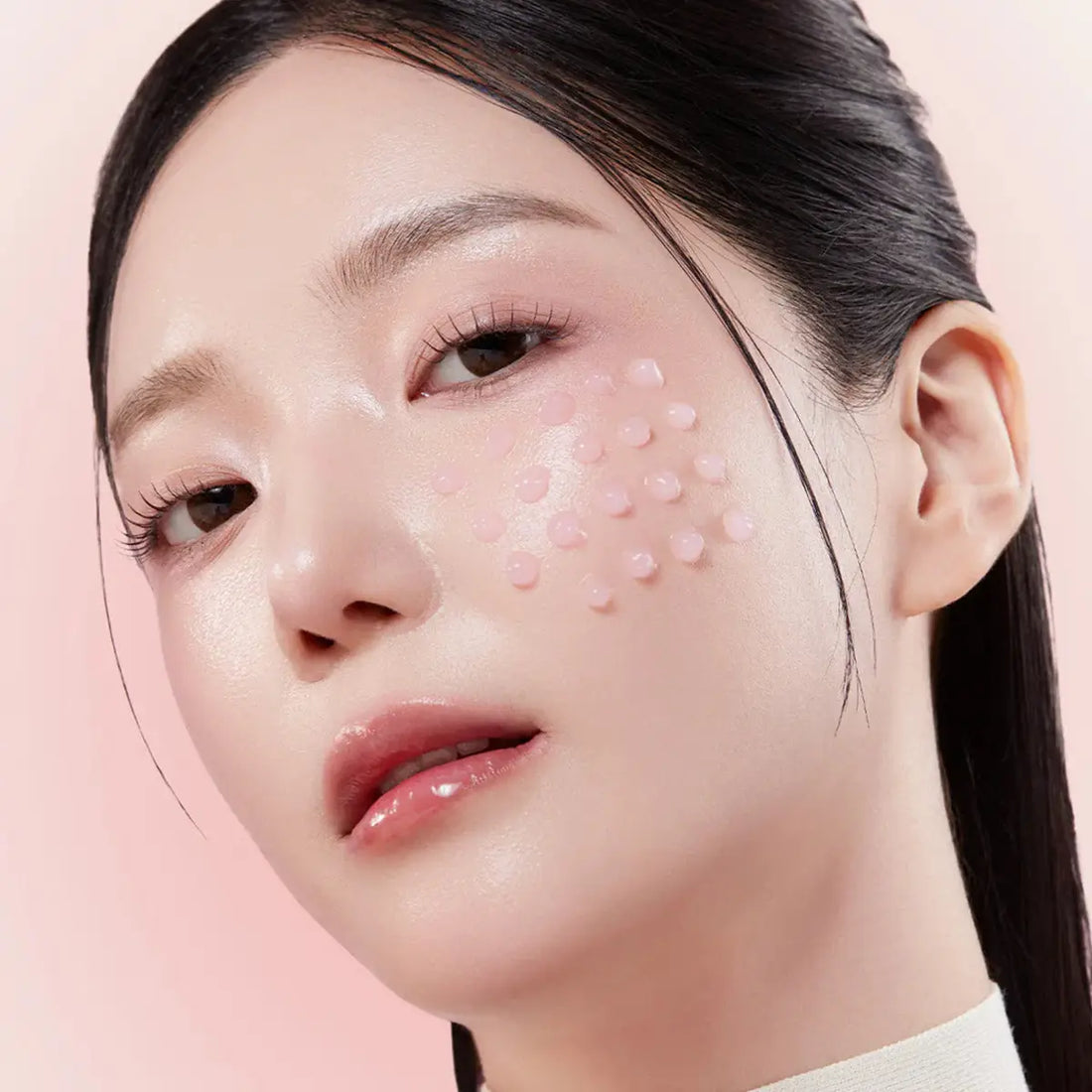 Close-up of a woman's face with a pink background