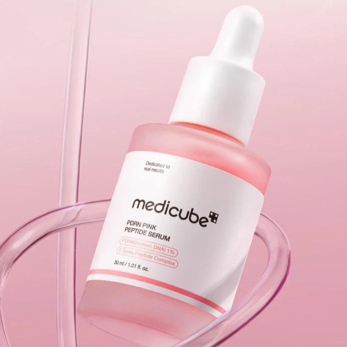 Medicube pink peptide serum bottle on a pink background
