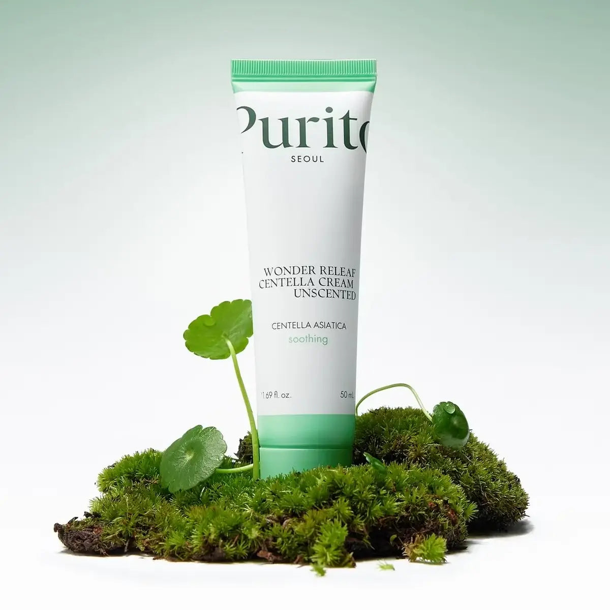 Tube of Purito skincare cream with green leaves and moss on a light background