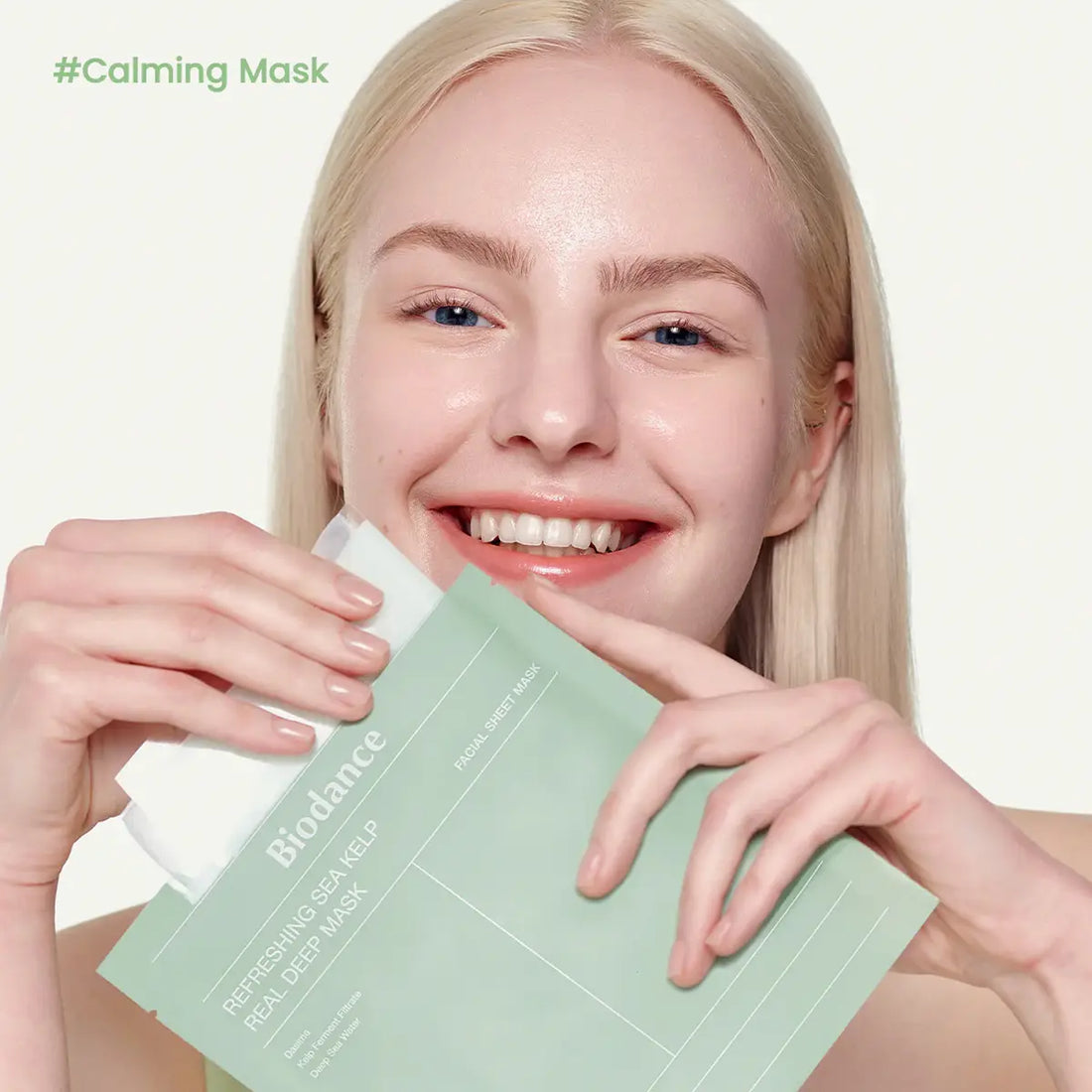 Woman holding a Biodance sheet mask with '#Calming Mask' text above her head.