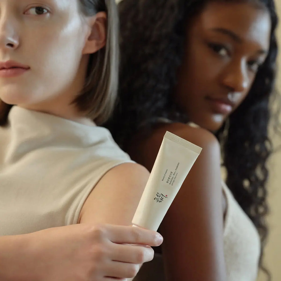 Two women with a tube of Beauty of Joseon Relief Sun Rice + Probiotics SPF50+ PA++++
