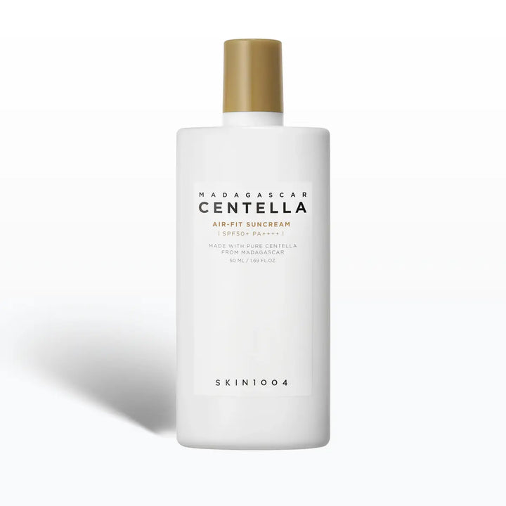 White bottle of Madagascar Centella sunscreen with gold cap on a white background