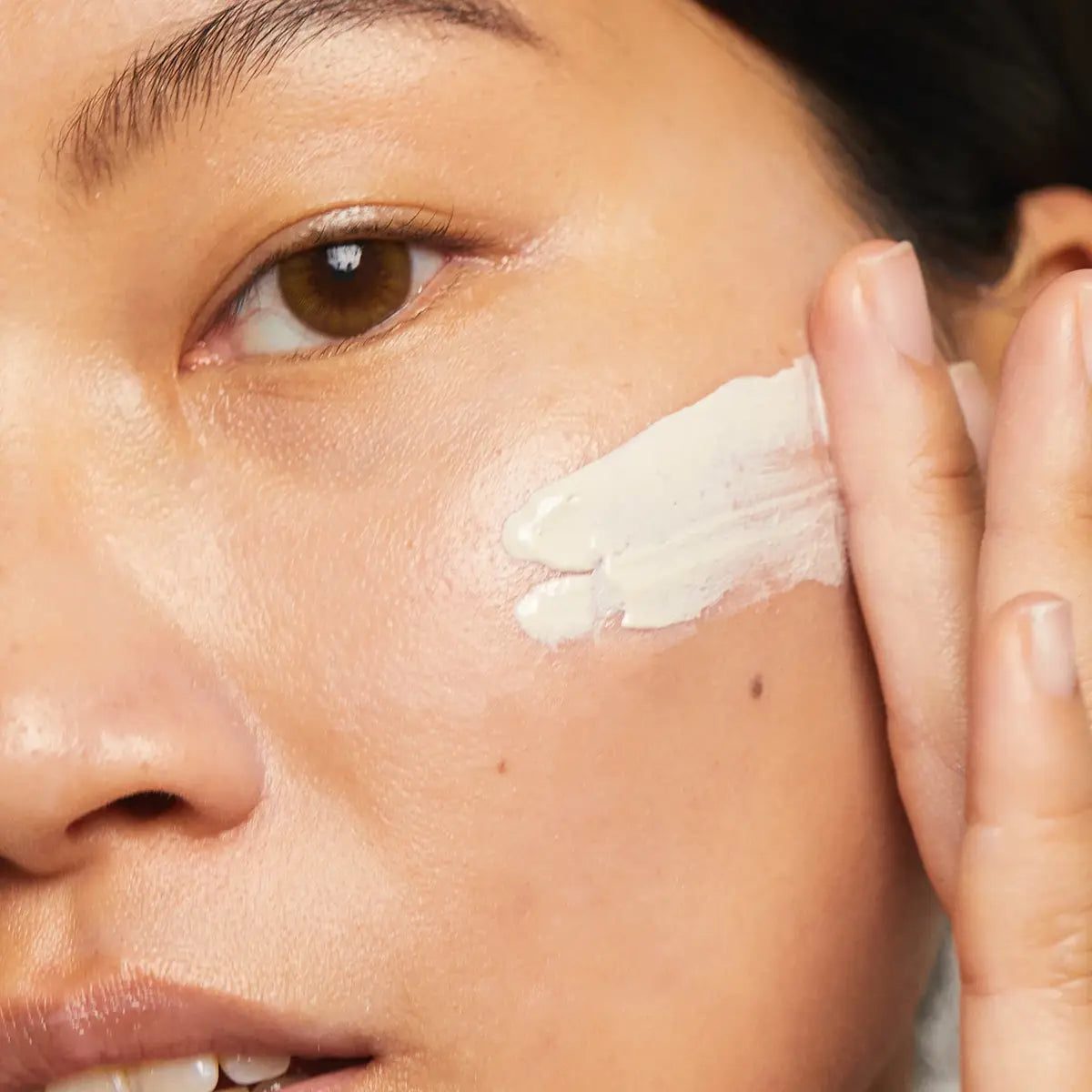 Person applying a white suncream to their face