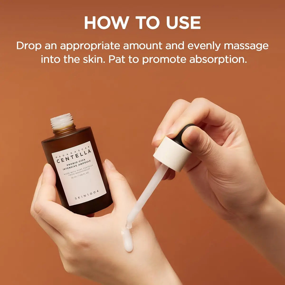 Hand holding a dropper with skincare product and bottle, against a brown background
