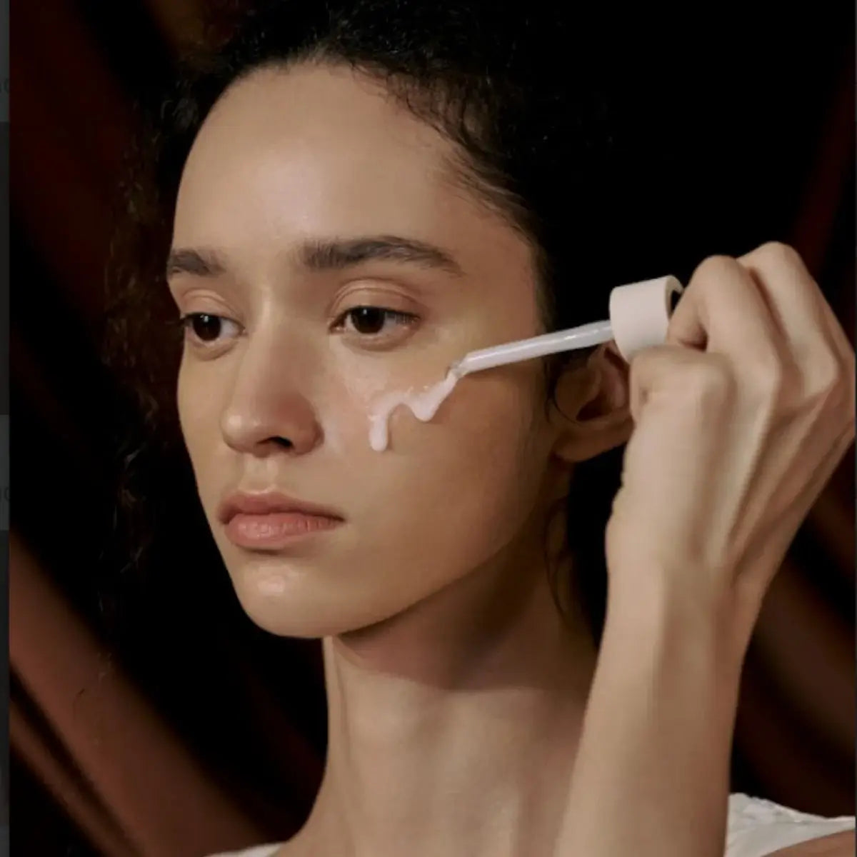 Person applyingSKIN1004 Madagascar Centella Probio-Cica Intensive Ampoule serum to their face with a brush